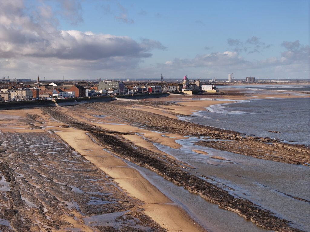 layers of fossil rich rock extend into the surf from redcar town